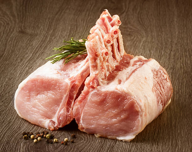 Raw meat with rosemary on wooden background