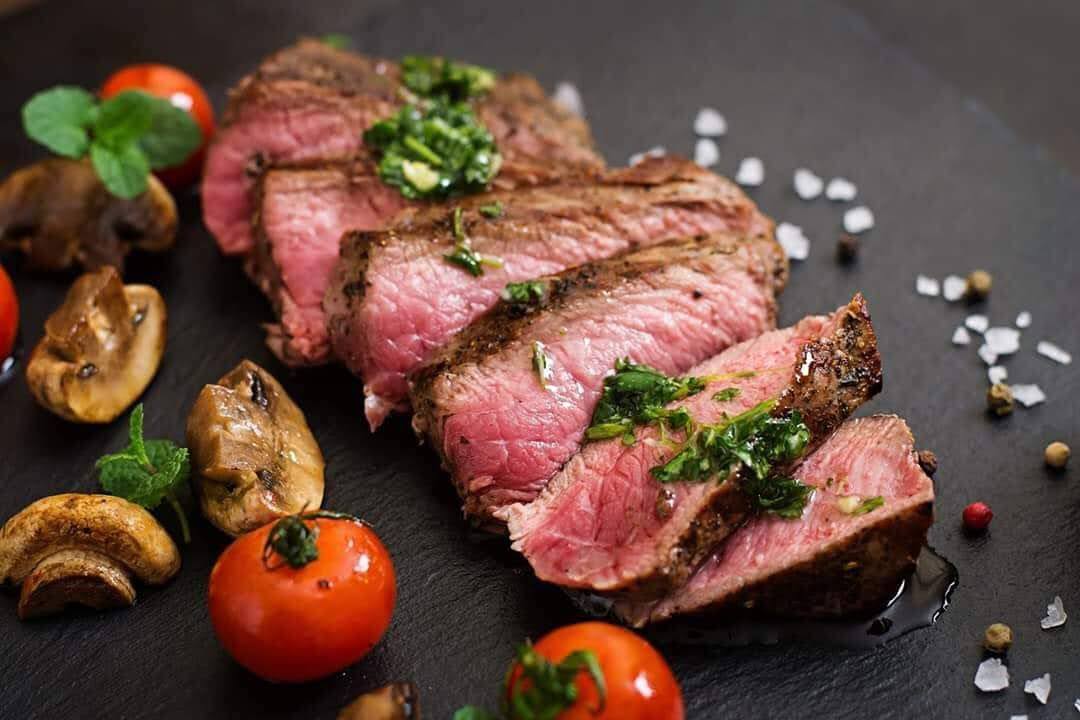 Bít tết bò cắt lát chín tới kèm nấm và cà chua